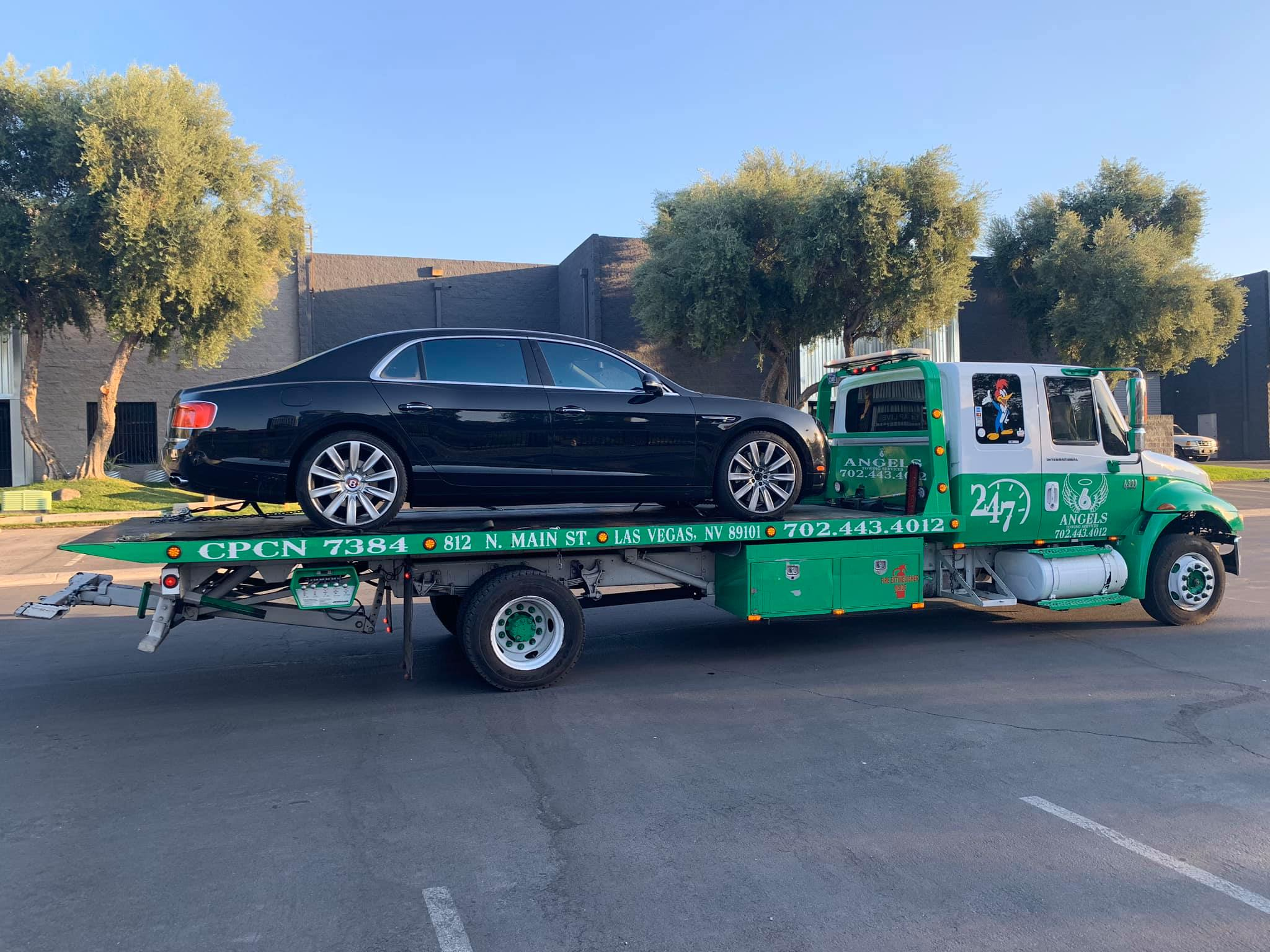 6 Angels tow truck carrying a luxury sedan through the Las Vegas area